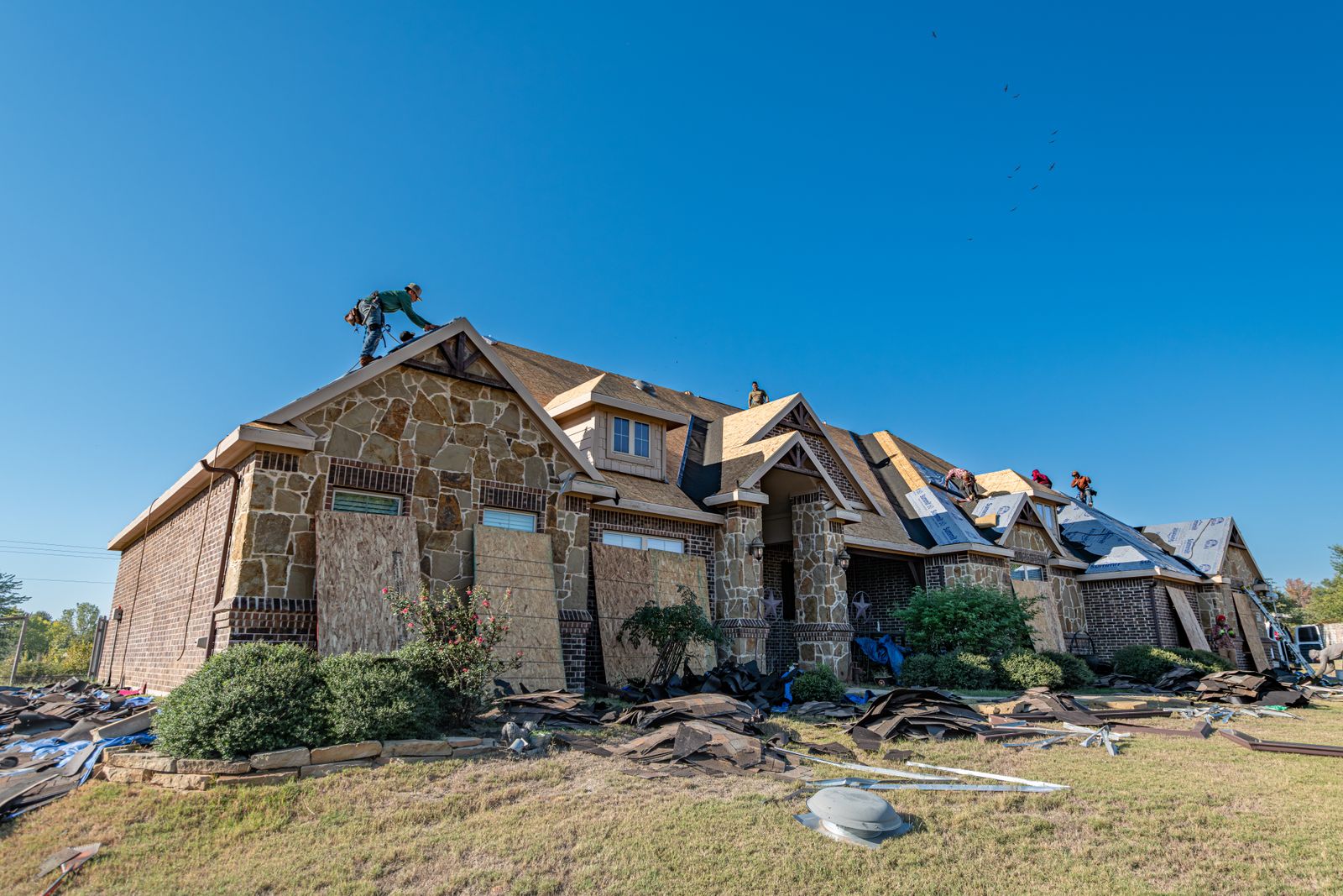 Crew working on a brick home roof in Weatherford, Texas