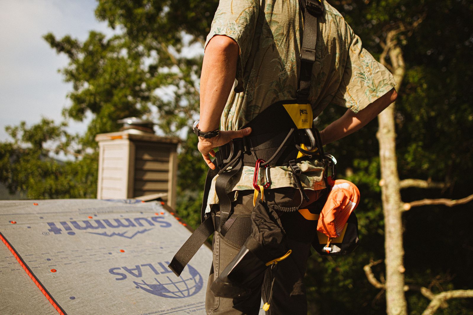 Roofer in a safety harness securing a damaged roof