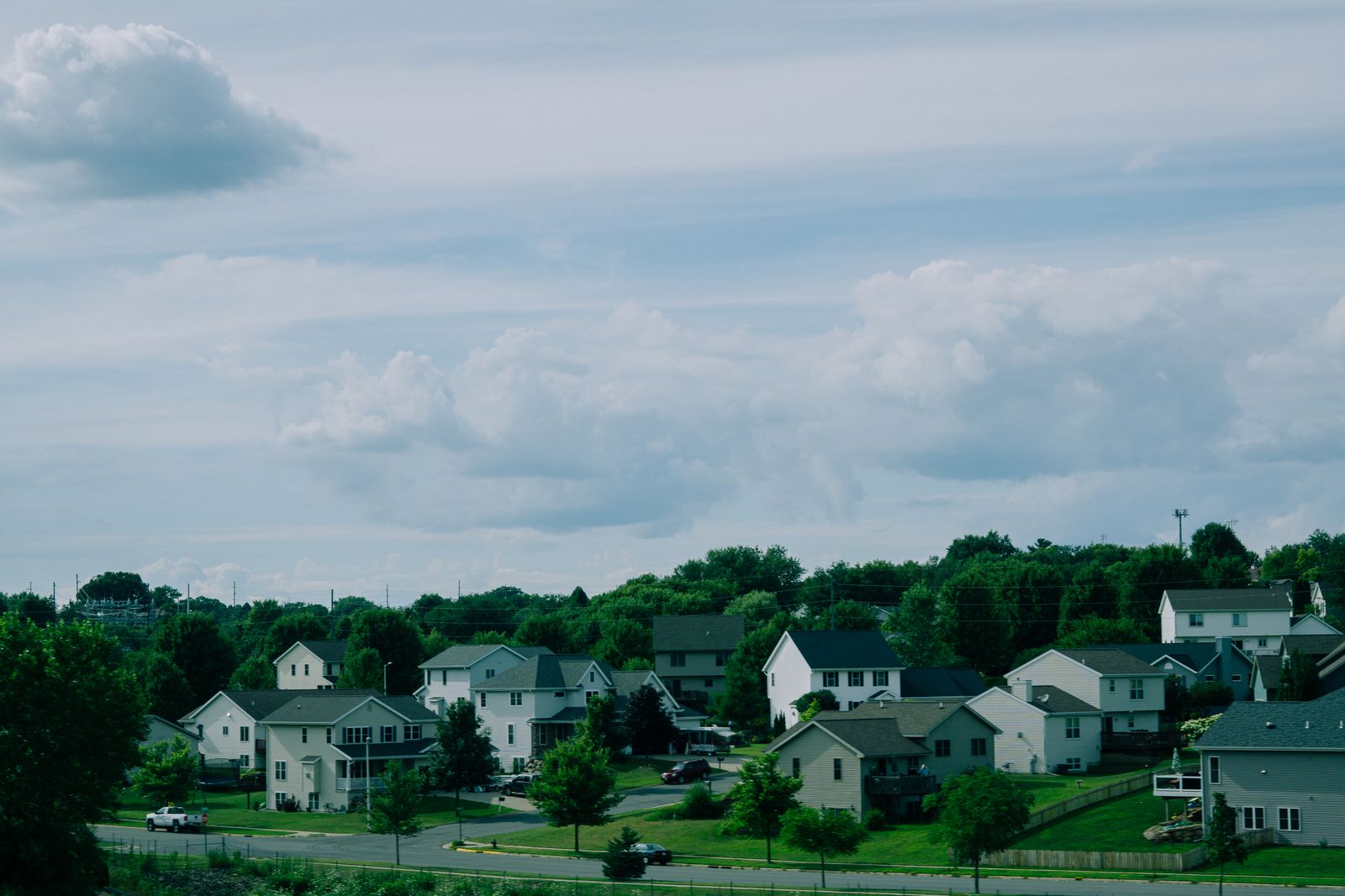 Suburban houses beneath a cloudy sky